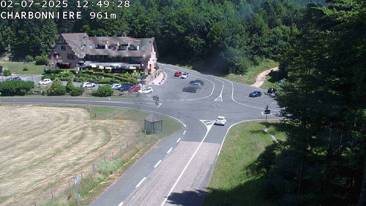 Webcam du col de la Charbonnière dans les Vosges en direction de la station du Champ du feu. Vue sur le D214 et la Tour du Champ du feu. Col de montagne à 961 mètres d'altitude