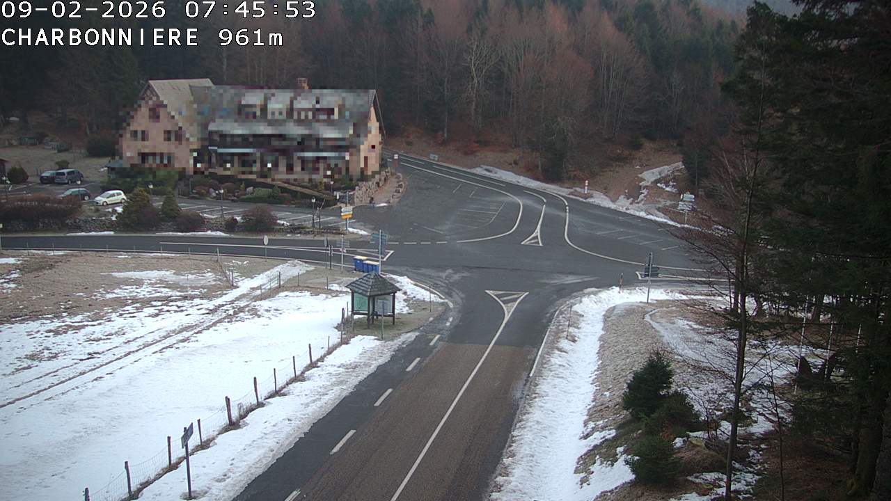 Webcam du col de la Charbonnière dans les Vosges en direction de la station du Champ du feu. Vue sur le D214 et la Tour du Champ du feu. Col de montagne à 961 mètres d'altitude