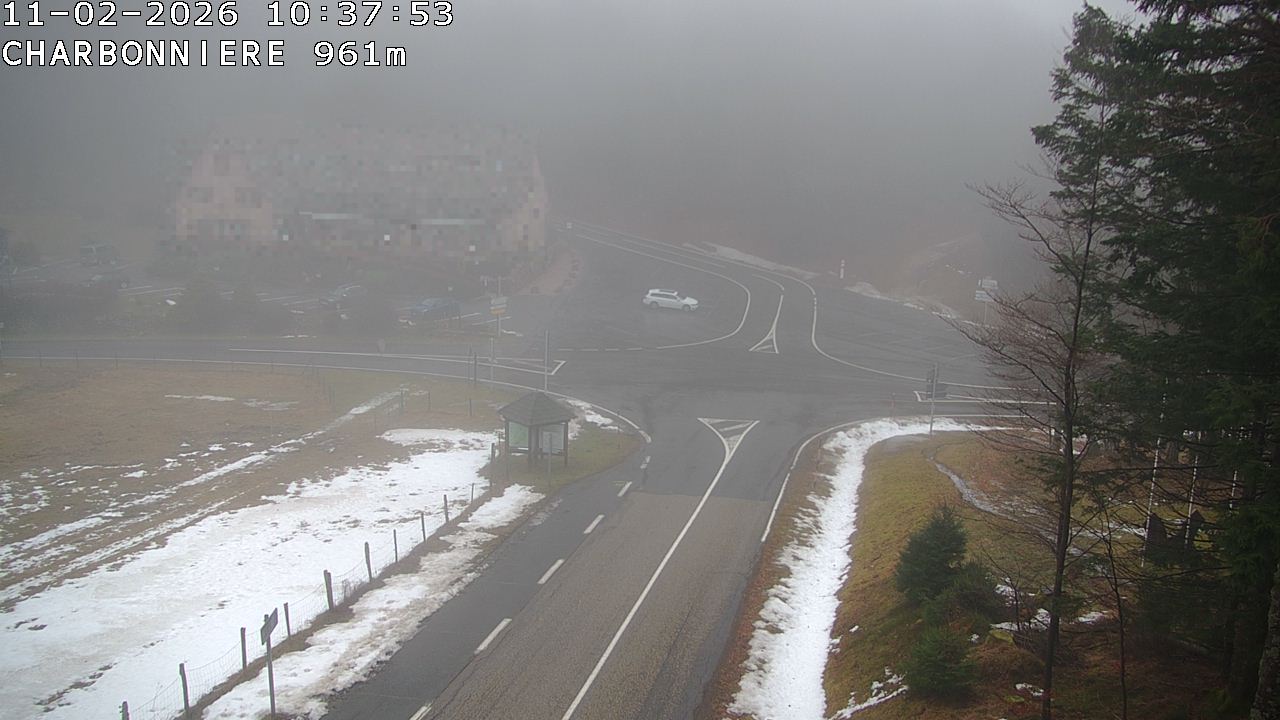 Webcam du col de la Charbonnière dans les Vosges en direction de la station du Champ du feu. Vue sur le D214 et la Tour du Champ du feu. Col de montagne à 961 mètres d'altitude